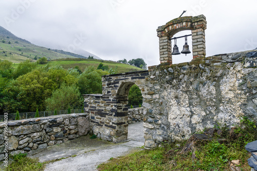 Cloudy view of the Church of Saint George of Dzivgis village in North Osetia Alania, North Caucasus, Russia photo