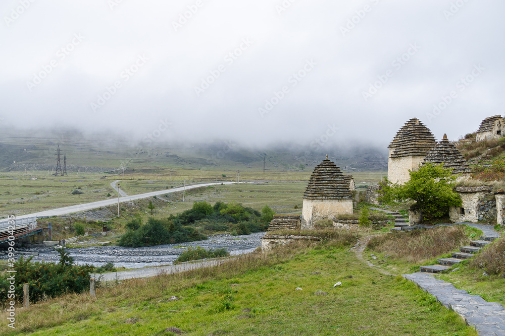 Cloudy view of ancient Alanian necropolis (the City of the Dead) of Dargavs village in North Osetia Alania, North Caucasus, Russia