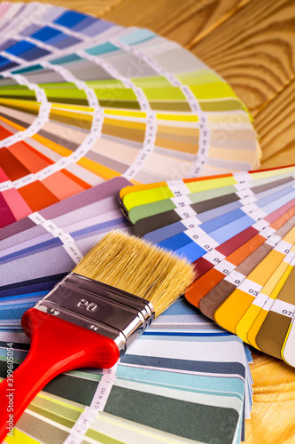 Color palette guide and brushes on wooden desktop