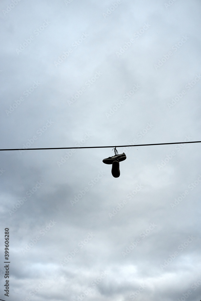 A pair of shoes hanging on a wire A pair of shoes hanging on a wire