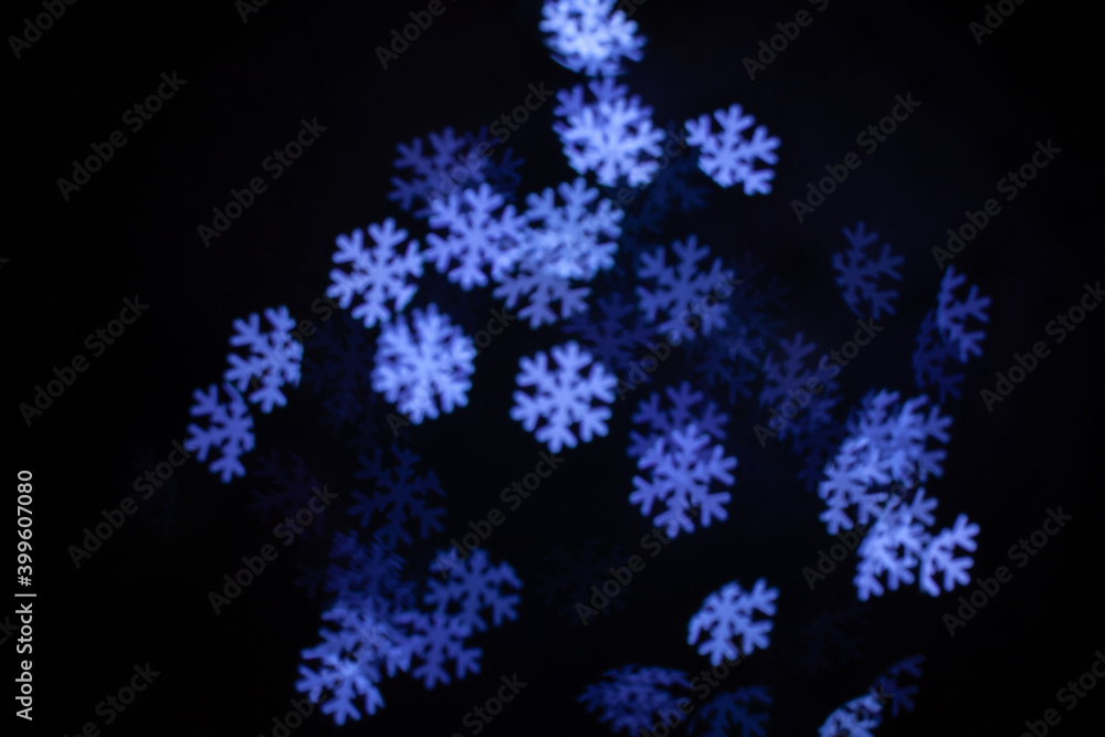 Christmas lights in the form of snowflakes. Blurred background. Flashing abstract colored circles defocused Christmas light video. Blurred fairy lights
