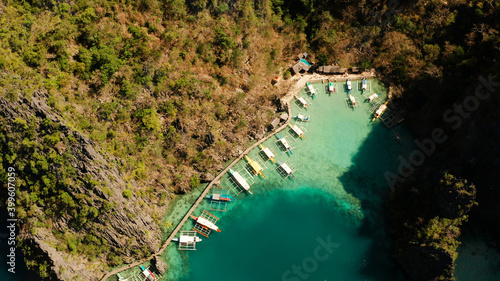 Aerial view tourist boats in lagoon. Kayangan Lake. lagoons, mountains covered with forests.coves with blue water among the rocks. Seascape, tropical landscape. Palawan, Philippines
