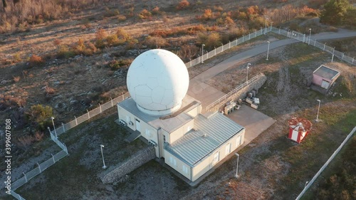 Giant radome sphere hiding radar antenna and surveillance equipment used by defense system. Dome or big cupola hiding airspace monitoring and intrusion detection station - civil and military.