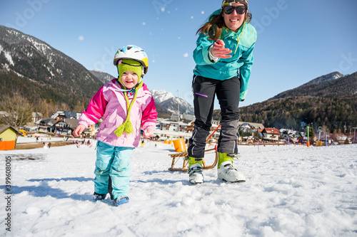 Cute girl having fun with her mother on ski resort.