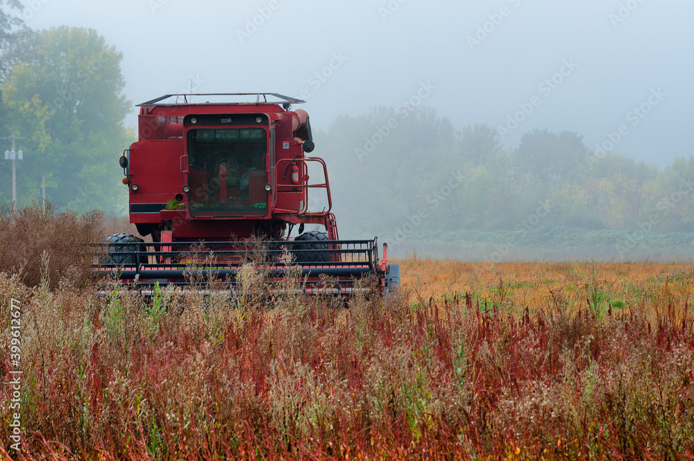 Fototapeta premium Agricultural Combine sits idle in a field