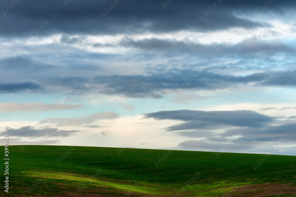 Minimalist of rolling agriculture field under cloudy skies