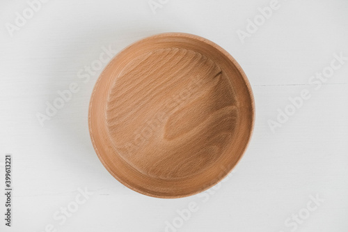 Empty wooden bowl on a white background. Top view. Copy, empty space for text
