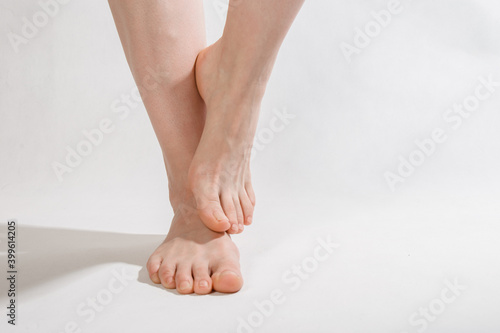 Fototapeta Naklejka Na Ścianę i Meble -  feet on a white background one foot lifted