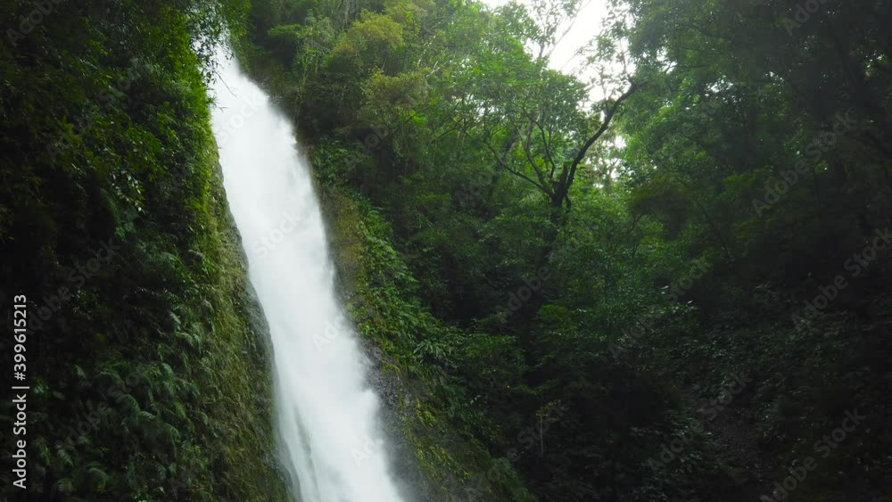 Jungle Waterfall in a tropical forest surrounded by green vegetation. Kabigan Falls in mountain jungle. Philippines, Luzon. Jungle Waterfall in a tropical forest surrounded by green vegetation. Kabigan Falls in mountain jungle. Philippines, Luzon.