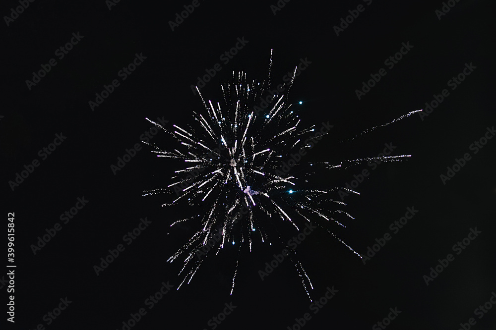 Fototapeta premium Large sparks from the explosion of fireworks against the black sky at night. Texture, photography.