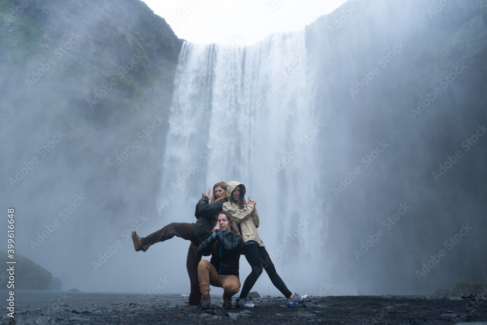 Obraz premium photo of happy tourist friends at the Skógafoss waterfall in Iceland