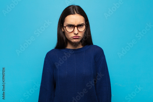 young hispanic woman feeling sad and whiney with an unhappy look, crying with a negative and frustrated attitude photo