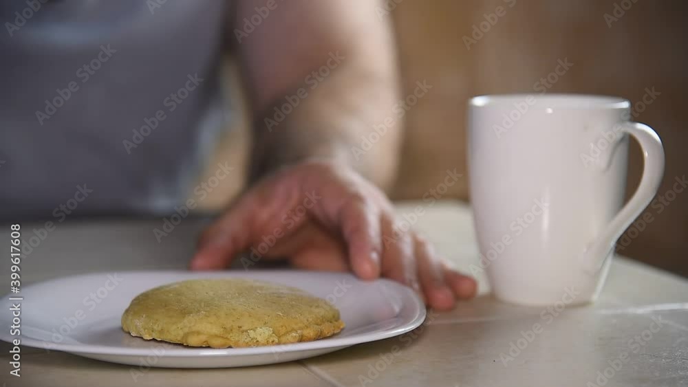 A man puts a lot of cakes on a plate, prepares breakfast.
