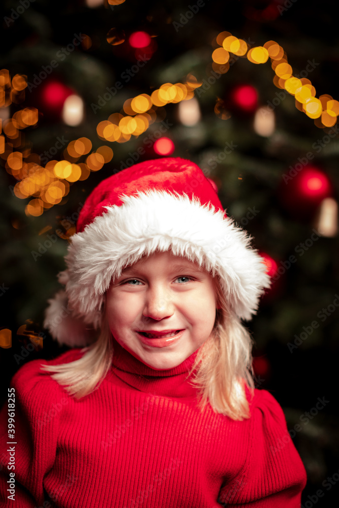 cute blond girl portrait in front of green christmas tree with fairy lights cute blond girl portrait in front of green christmas tree with fairy lights