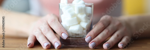 Female hands hold glass with sugar. Sugar addiction how to get rid of concept