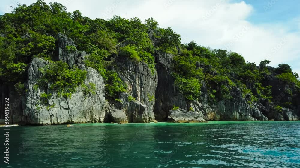 Rocky tropical island covered by forest and tropical vegetation, Boat view. Camarines Sur, Philippines. Philippine Islands. Rocky tropical island covered by forest and tropical vegetation, Boat view. Camarines Sur, Philippines. Philippine Islands.