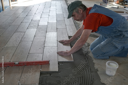 the worker puts ceramic tiles on the construction site