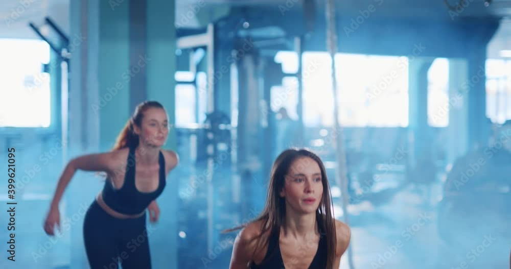 Determined pretty muscular three women doing jumpin exercises on boxes training their obliques working out in the gym. Female workout. Active lifestyle. Determined pretty muscular three women doing jumpin exercises on boxes training their obliques working out in the gym. Female workout. Active lifestyle.