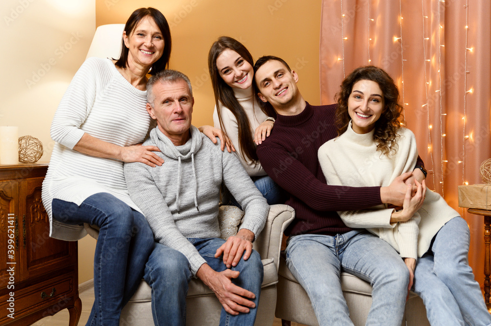 a group of people of different ages. father, son, mother, sister, wife, daughter, husband. New Year's holidays, Christmas mood. the room is decorated with New Year's decorations. happy family. a group of people of different ages. father, son, mother, sister, wife, daughter, husband. New Year's holidays, Christmas mood. the room is decorated with New Year's decorations. happy family.
