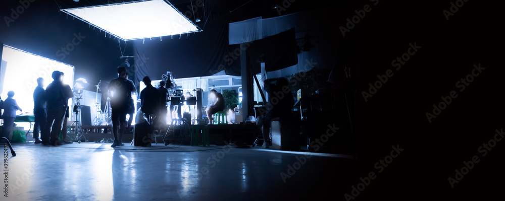 Silhouette images of video production behind the scenes or b-roll or making of TV commercial movies that film crew team lightman and videos cameraman working together with movie director in studio. - obrazy, fototapety, plakaty 