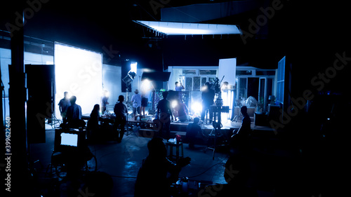 Foto Silhouette images of video production behind the scenes or b-roll or making of TV commercial movies that film crew team lightman and videos cameraman working together with movie director in studio