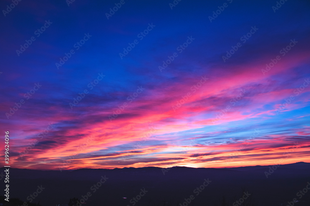 Spectacular winter sunset with clouds with red and pink colors crossing the sky after a long motorbike ride Spectacular winter sunset with clouds with red and pink colors crossing the sky after a long motorbike ride