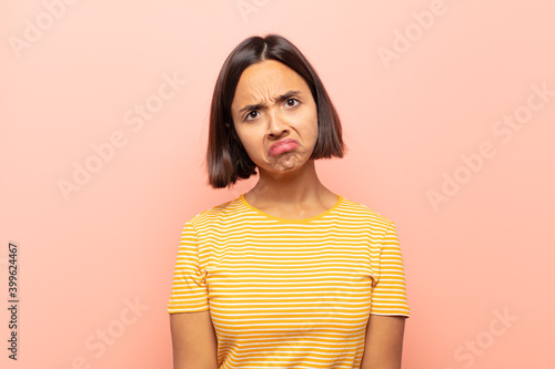 young hispanic woman feeling sad and whiney with an unhappy look, crying with a negative and frustrated attitude photo