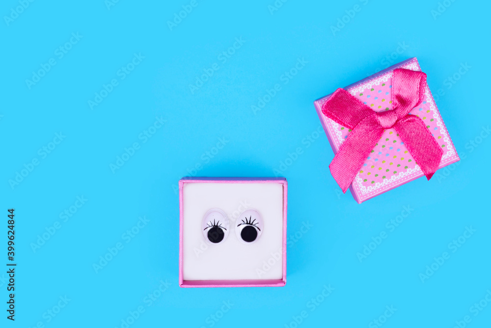 Cute gift box with eyes. Minimal shopping concept on light blue background. Cute gift box with eyes. Minimal shopping concept on light blue background.
