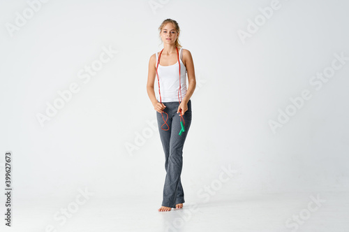 sporty woman with skipping rope and in gray fitness pants 