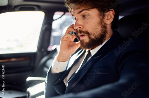 successful rich man in a suit talking on the phone while driving a passenger car © SHOTPRIME STUDIO
