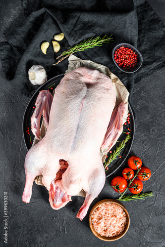 Recipe for cooking whole duck with pink pepper and rosemary. Black background. Top view. Space for text