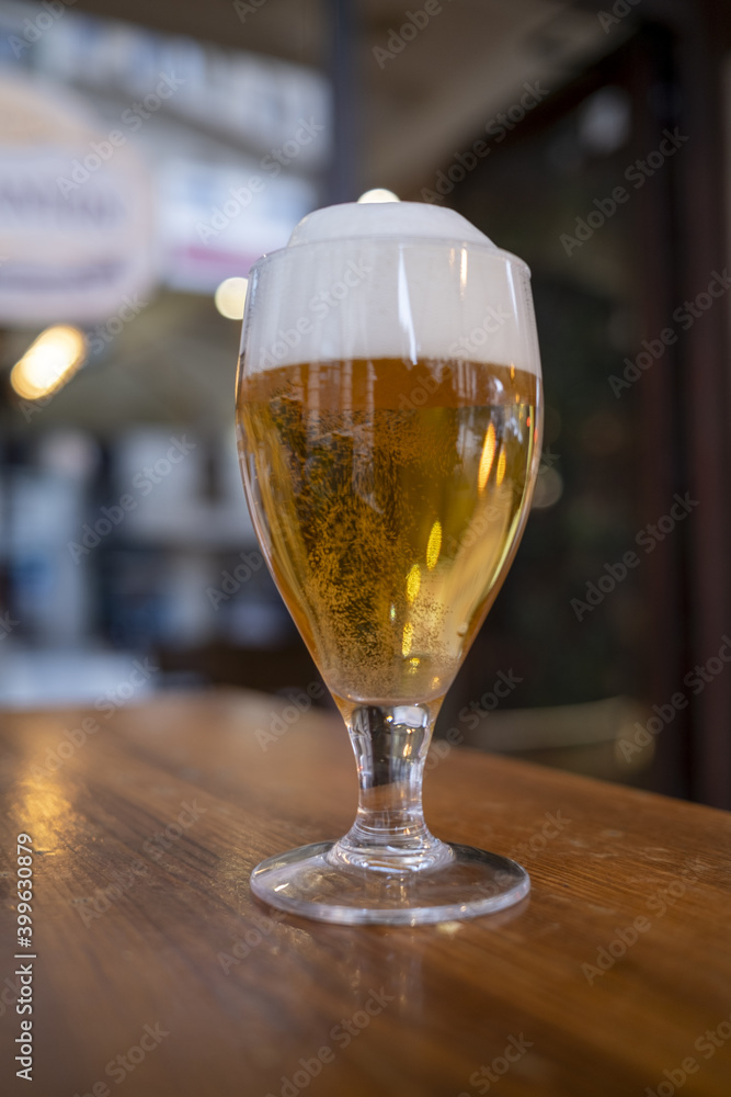 Glass of light beer on a table in the bar Glass of light beer on a table in the bar