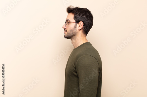 young handsome man on profile view looking to copy space ahead, thinking, imagining or daydreaming photo