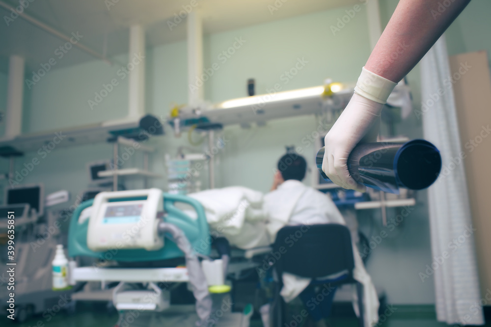 CT scan in the gloved hand of medical doctor on the background of person sitting by the patient's bed CT scan in the gloved hand of medical doctor on the background of person sitting by the patient's bed
