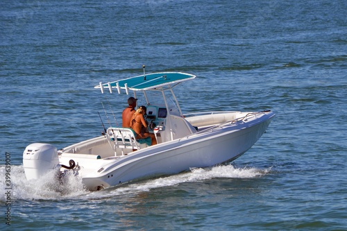 Young couple cruising in an open white fishing boat.