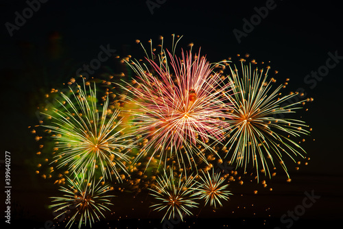 Festive fireworks in the sky for a holiday. Bright multi-colored salute on a black background. Place for text.