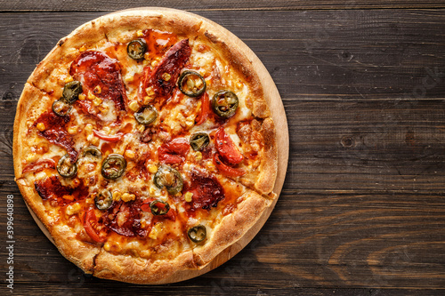 Fresh pizza with tomato sauce, black olives, mozzarella cheese, ham on wooden table closeup. Space for text or copy space. Pizza menu. Restaurant menu advertise