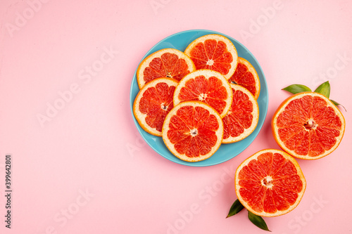 top view tasty grapefruits fruit slices inside plate on a pink background mellow fresh citrus fruit juice color diet