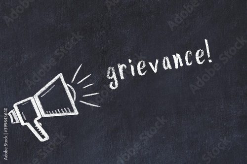 Chalk loudspeaker and inscription grievance on black chalkboard