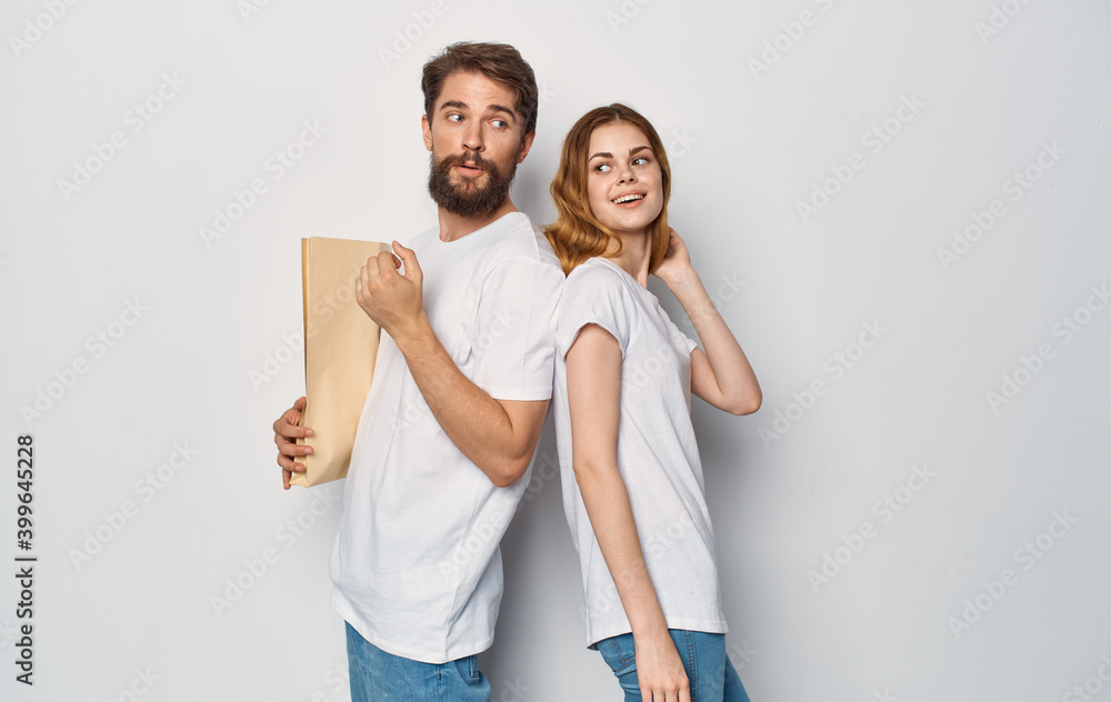Cheerful married couple t-shirts package in the hands of a man Shopping is joy Cheerful married couple t-shirts package in the hands of a man Shopping is joy