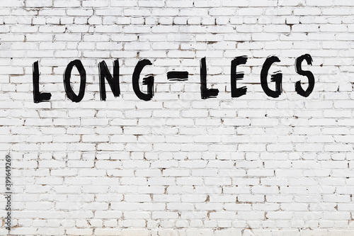 Inscription long-legs painted on white brick wall