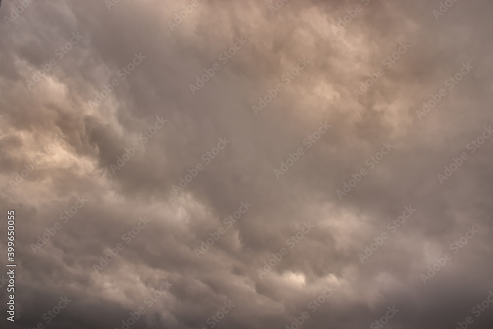 sky covered by gray and orange shaded rain clouds.