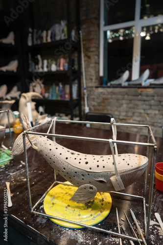Clay whale on a stand in a pottery workshop © teksomolika