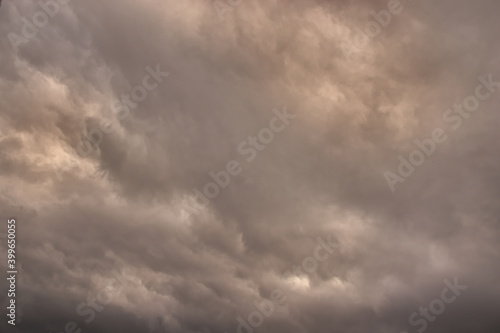 sky covered by gray and orange shaded rain clouds.