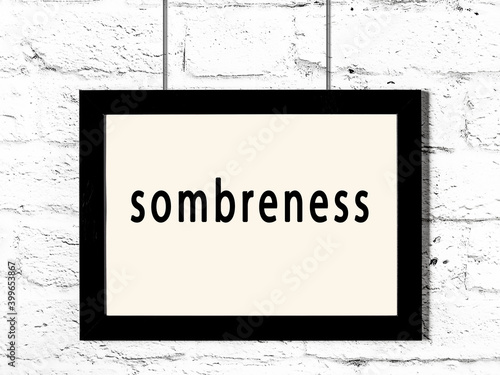 Canvas-taulu Black frame hanging on white brick wall with inscription sombreness
