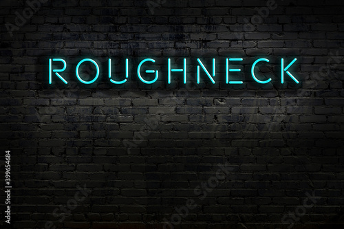 Night view of neon sign on brick wall with inscription roughneck photo