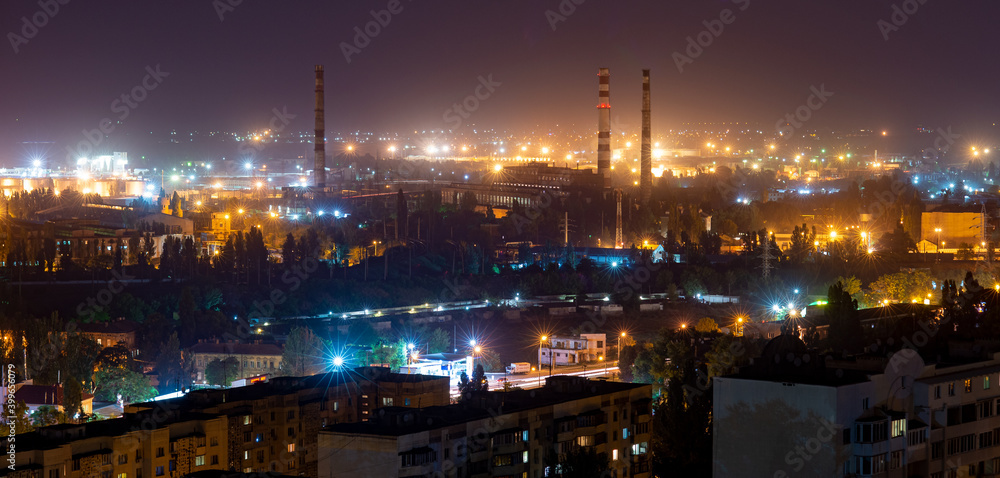 Panorama of the night city. Industrial area. Factory pipes without smoke