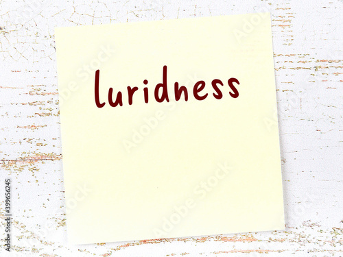 Yellow sheet of paper with word luridness. Reminder concept