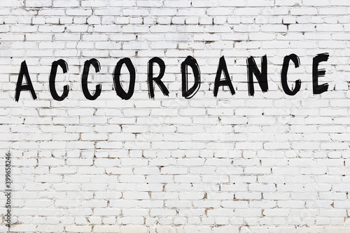 White wall with black paint inscription accordance on it
