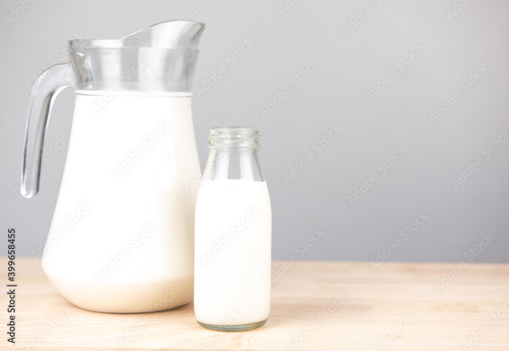 jug and bottle of fresh milk glass on wooden table background. .Raw milk is high in calcium and protein to drink for all ages..Milk consumption nutritious and healthy dairy products concept. jug and bottle of fresh milk glass on wooden table background. .Raw milk is high in calcium and protein to drink for all ages..Milk consumption nutritious and healthy dairy products concept.